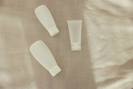Unbranded skincare tubes on linen