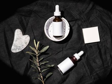 Skincare tools on a dark surface